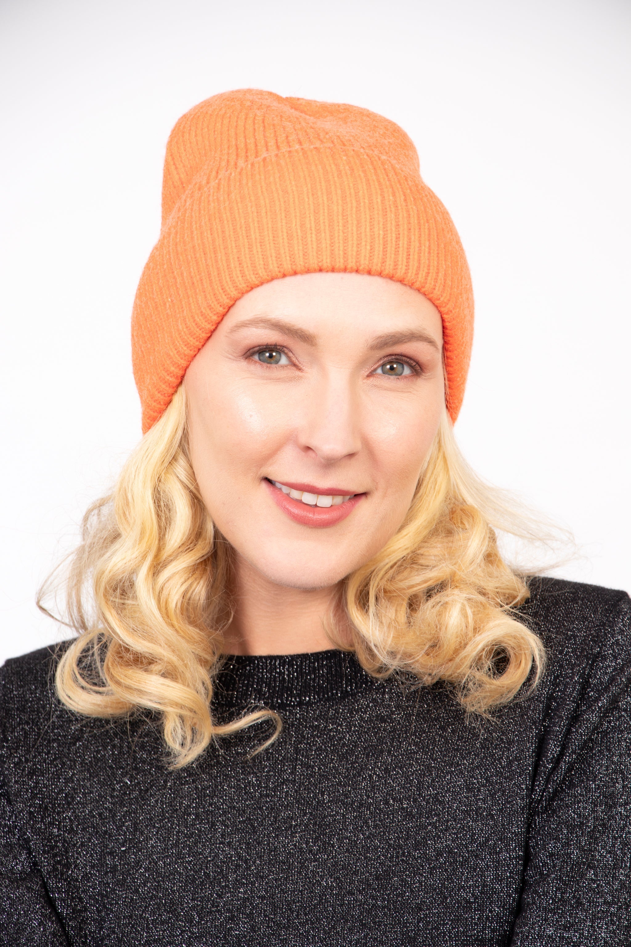 model wearing a plain orange ribbed beanie knitted hat