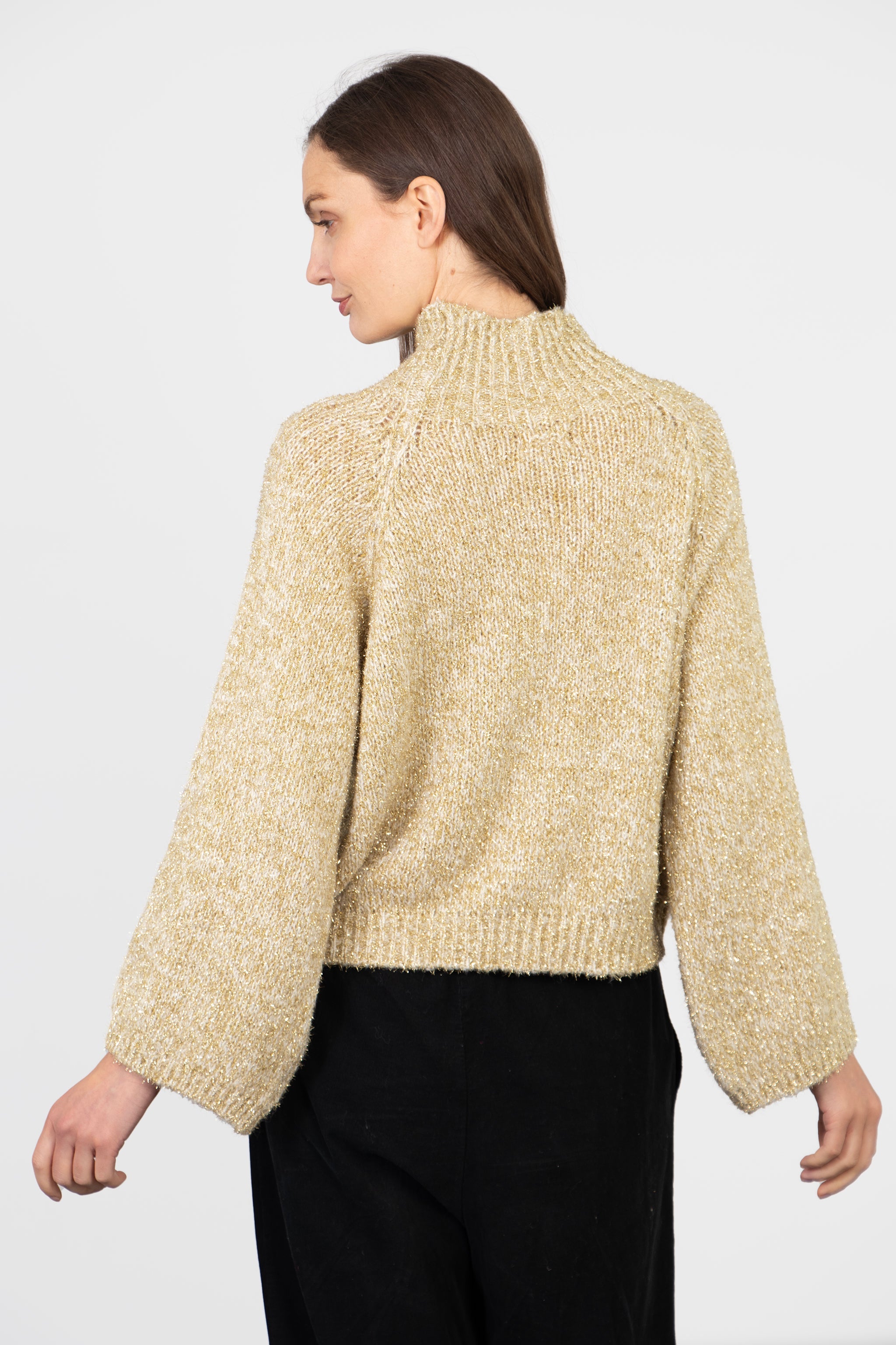 model showing the back of the jumper, it is plain sparkly gold no pattern