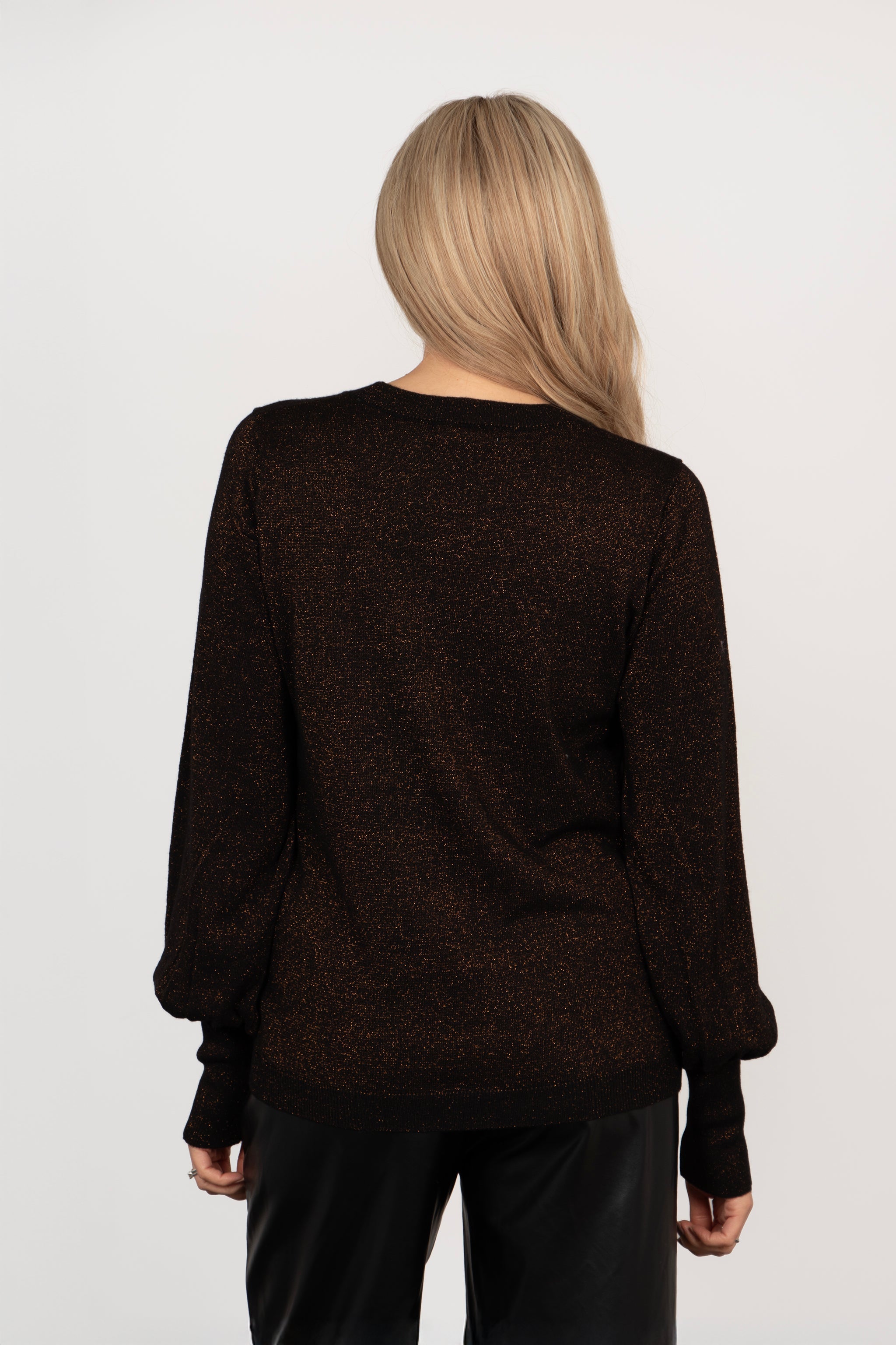 model showing the back of the jumper, the balloon sleeves with the fitted cuffs are clearly shown as is the all over sparkle