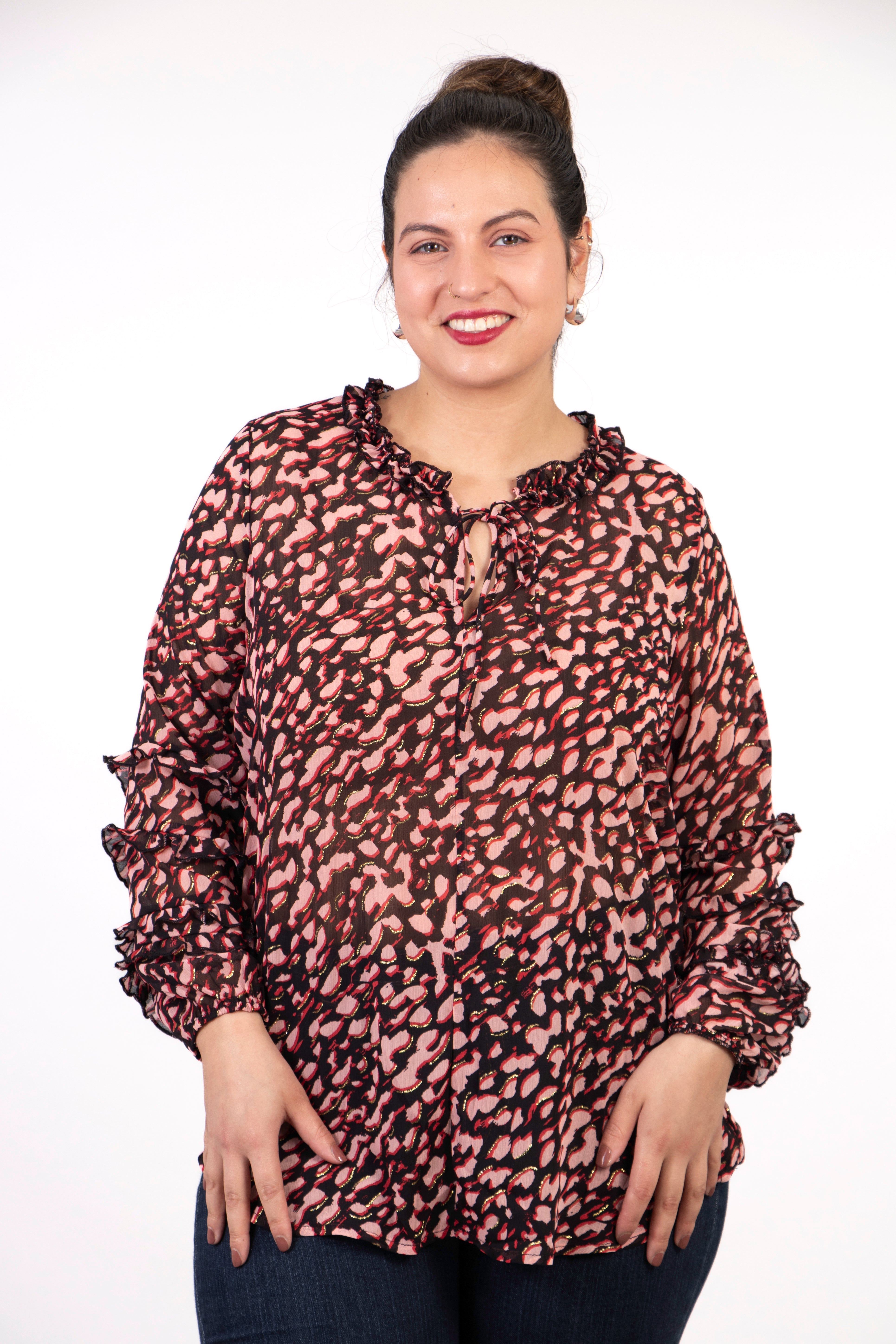 model wearing a long sleeve pink leopard print blouse with gold metallic highlights, the blouse has long sleeves and a ruffles grandad collar