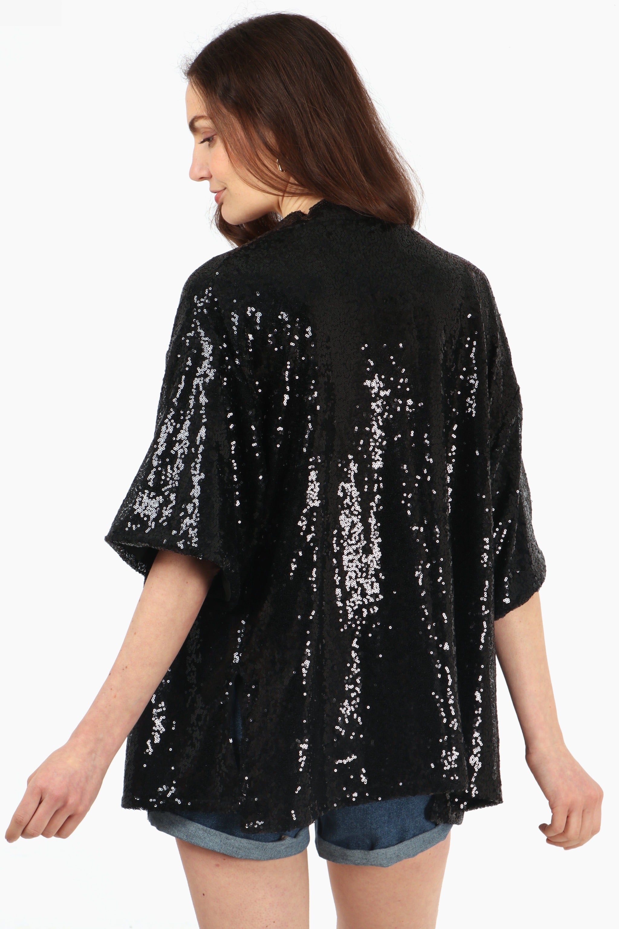 model showing the back of the sequin kimono top, showing an all over sparkly effect