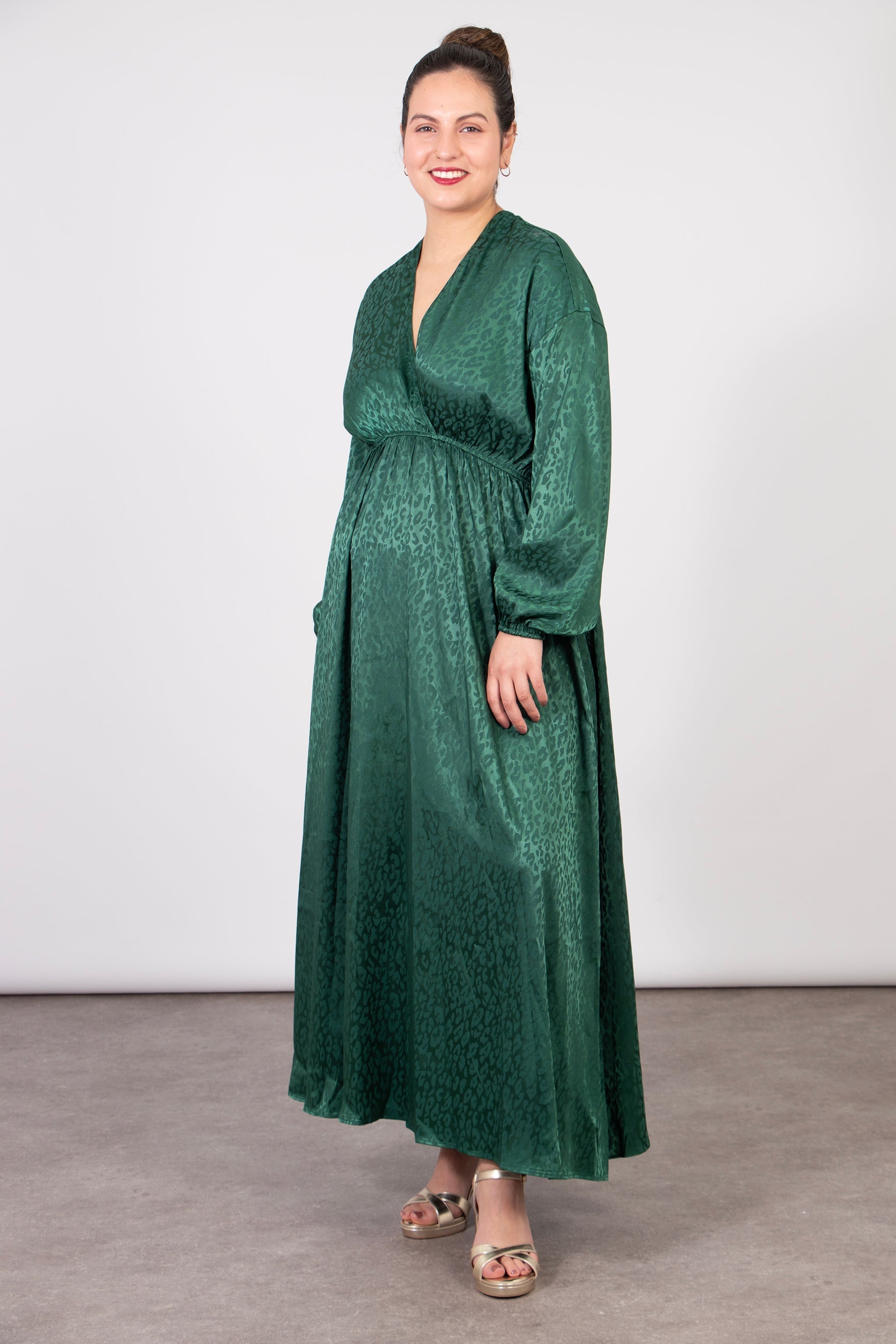 model wearing a long sleeve faux wrap dress in green with an all over leopard print pattern