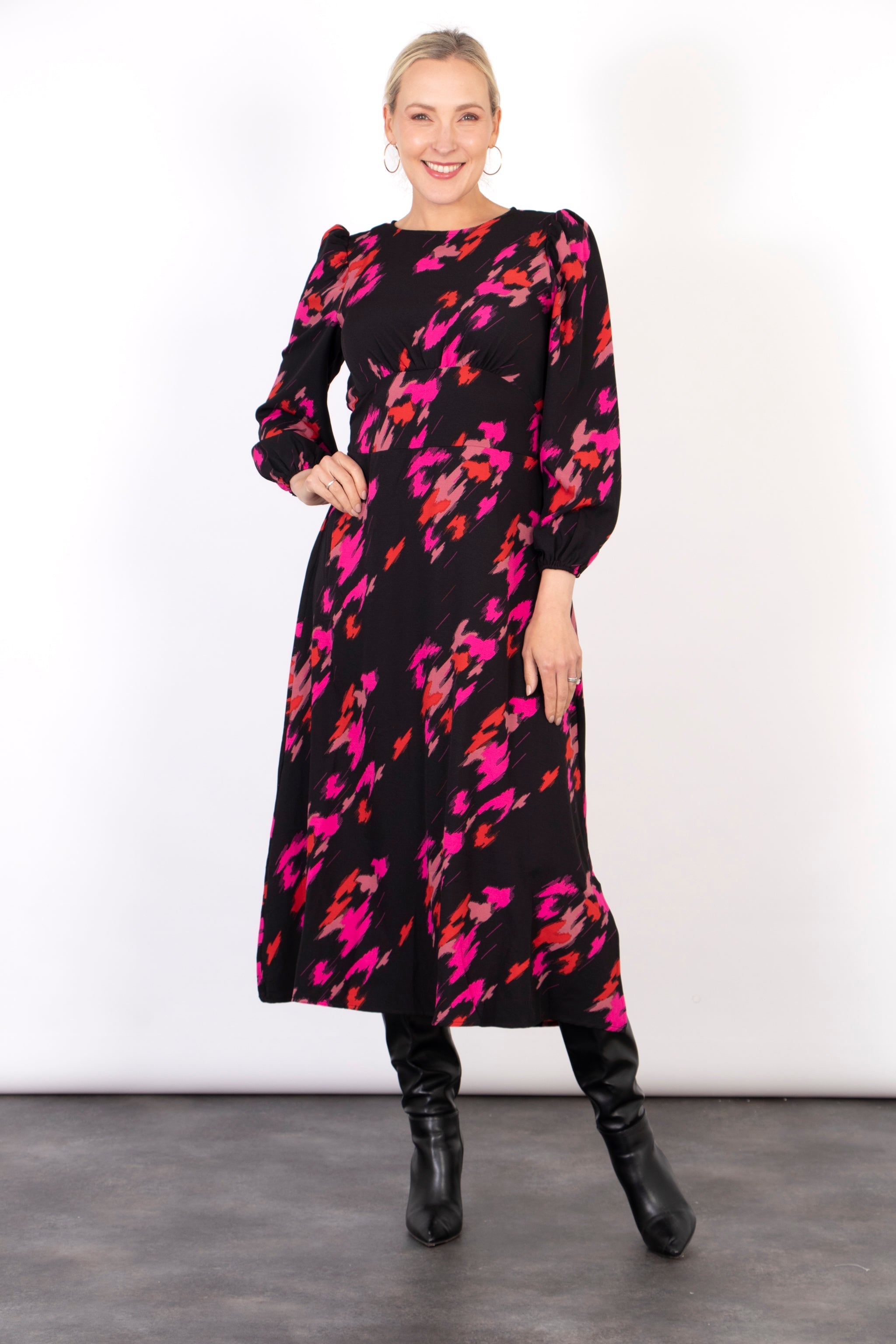 black tea dress with a bold pink abstract animal print pattern all over, the dress has a round neck and long sleeves