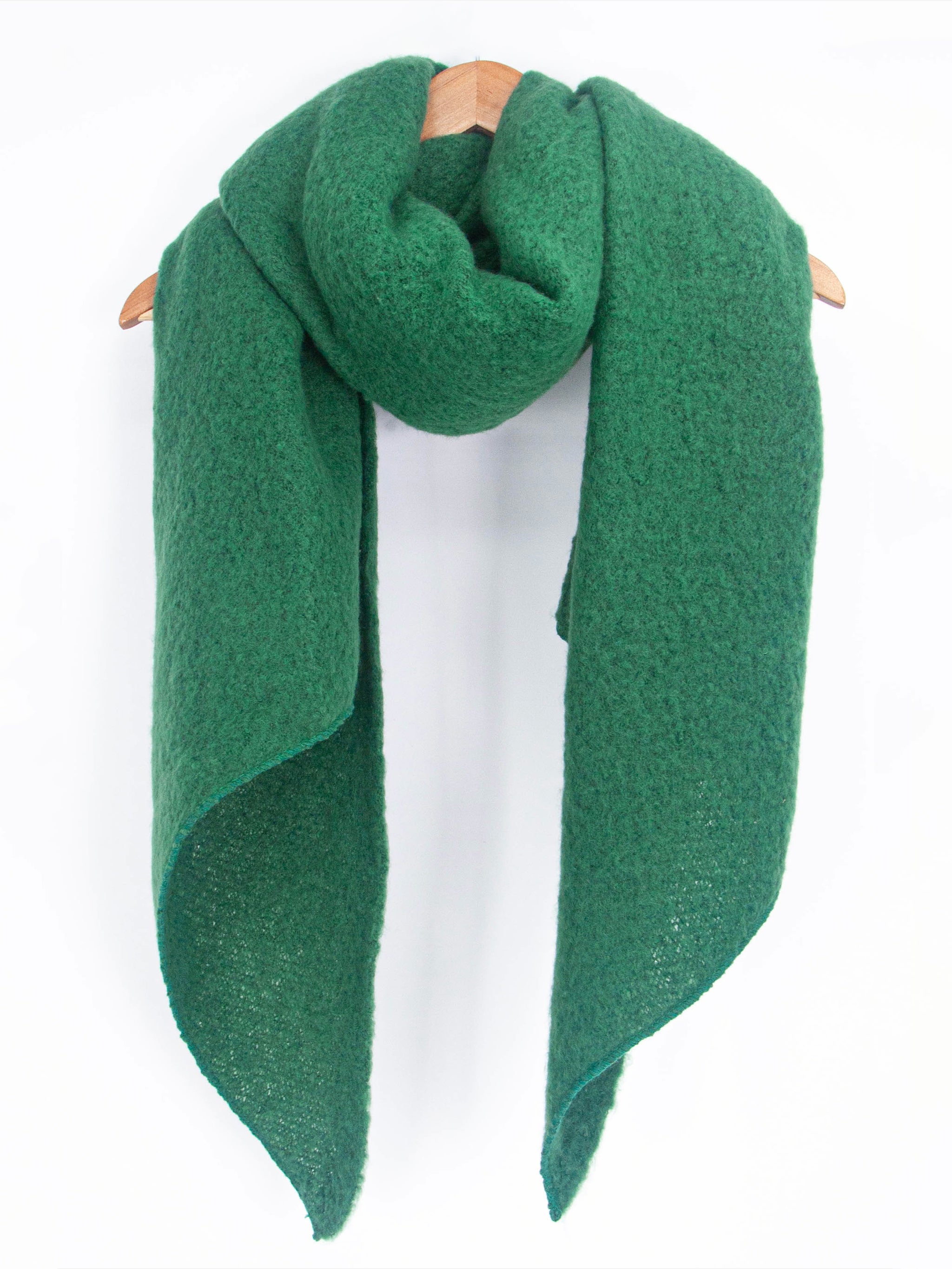 asymmetric green scarf draped around a coat hanger