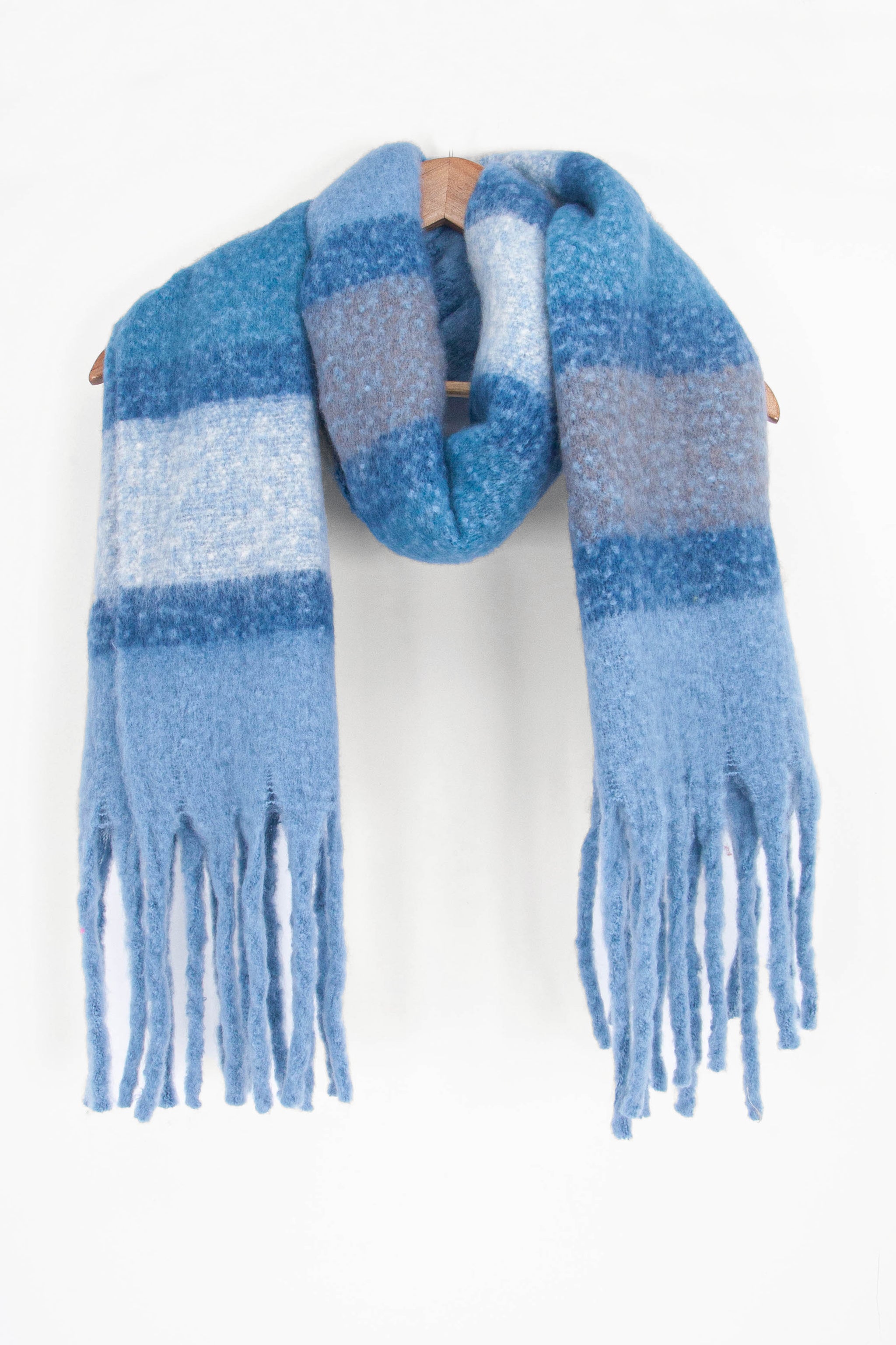 showing the blue colour block striped winter scarf draped around a coat hanger