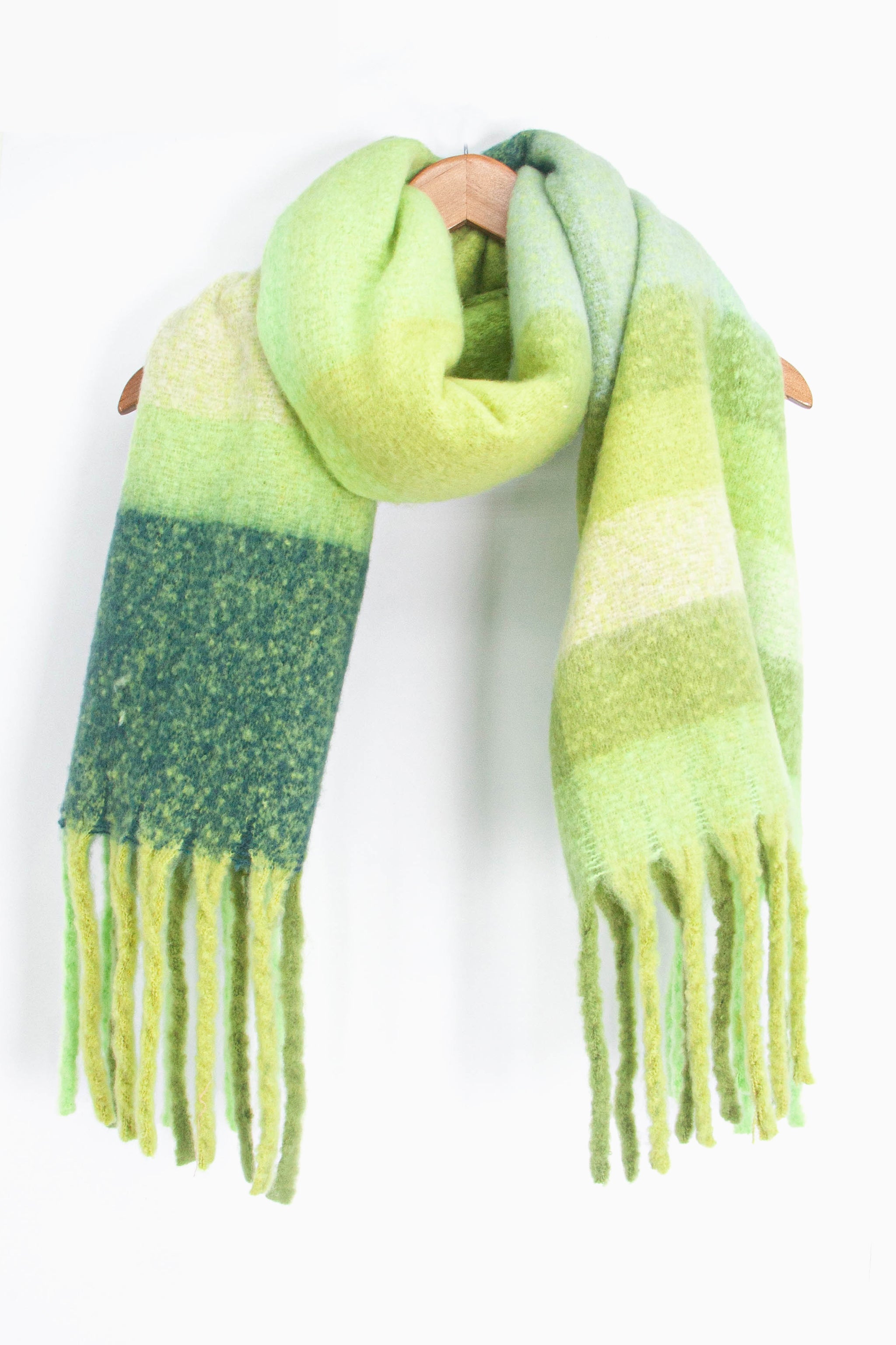 showing the green colour block striped winter scarf draped around a coat hanger