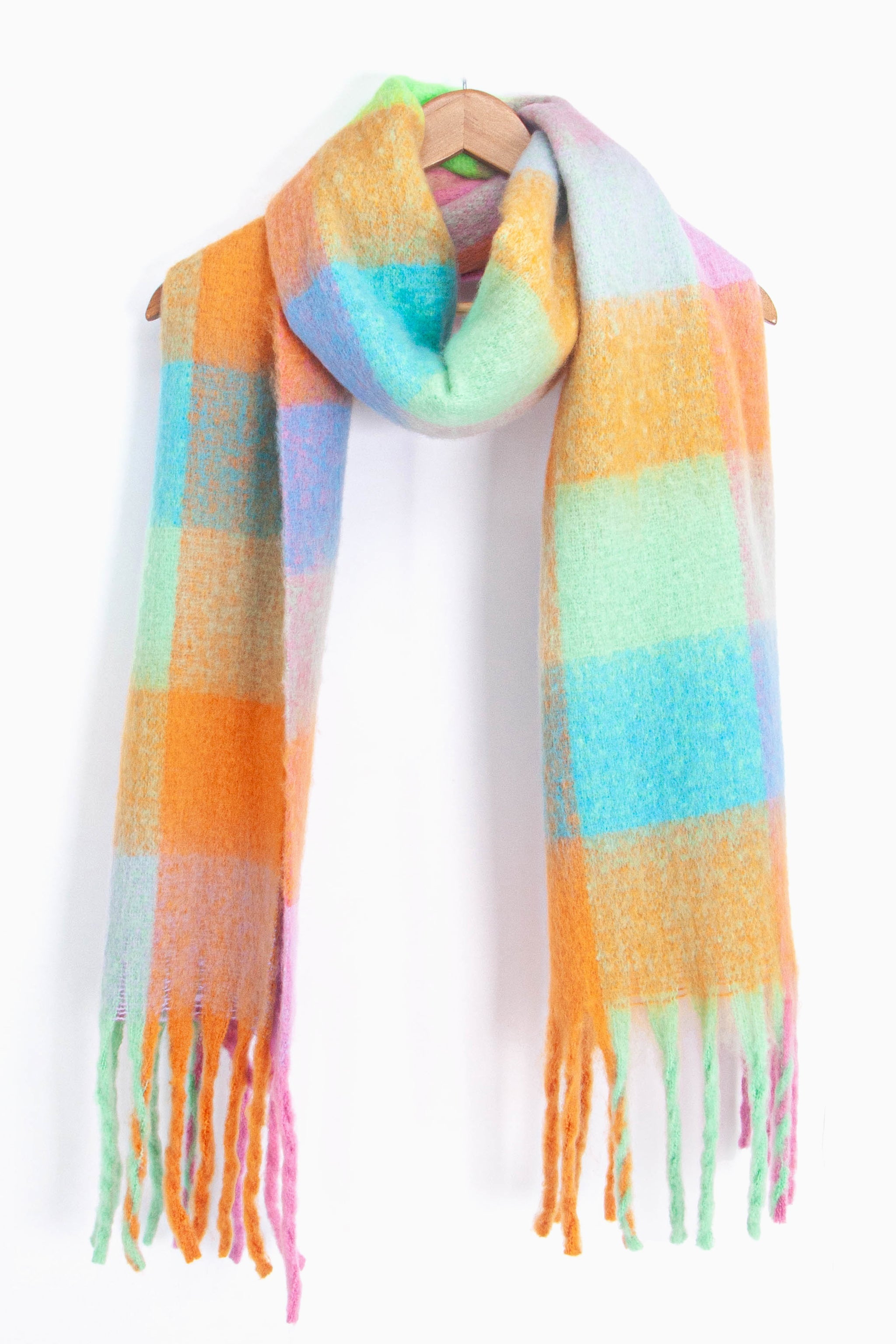 showing the multicoloured square colour block winter scarf draped around a coat hanger, showing how it would look when worn.
