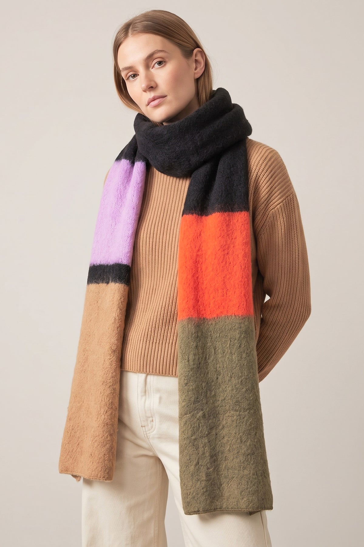 colour block winter scarf made from soft knitted viscose, the scarf has orange, khaki, black, neutral and lilac blocks of colour in the design.