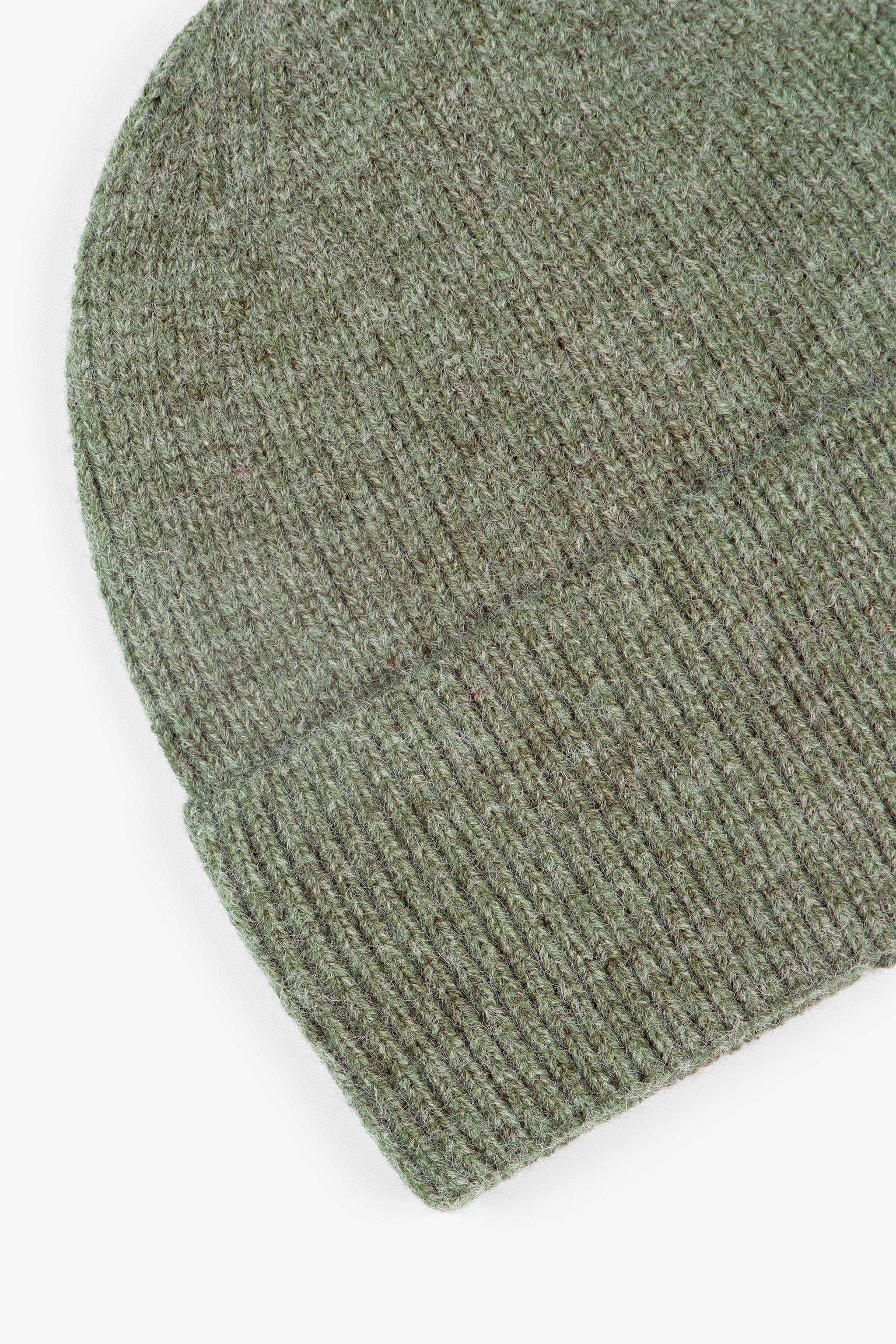 close up of the brim of the khaki green knitted beanie hat, showing the ribbed design