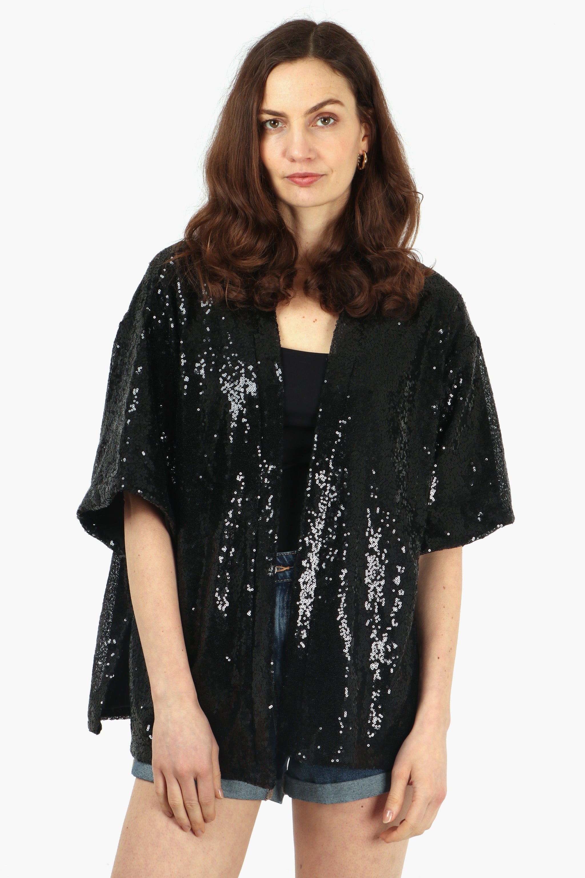 model wearing a black sequin evening kimono jacket with 3/4 sleeves and an all over sparkle effect