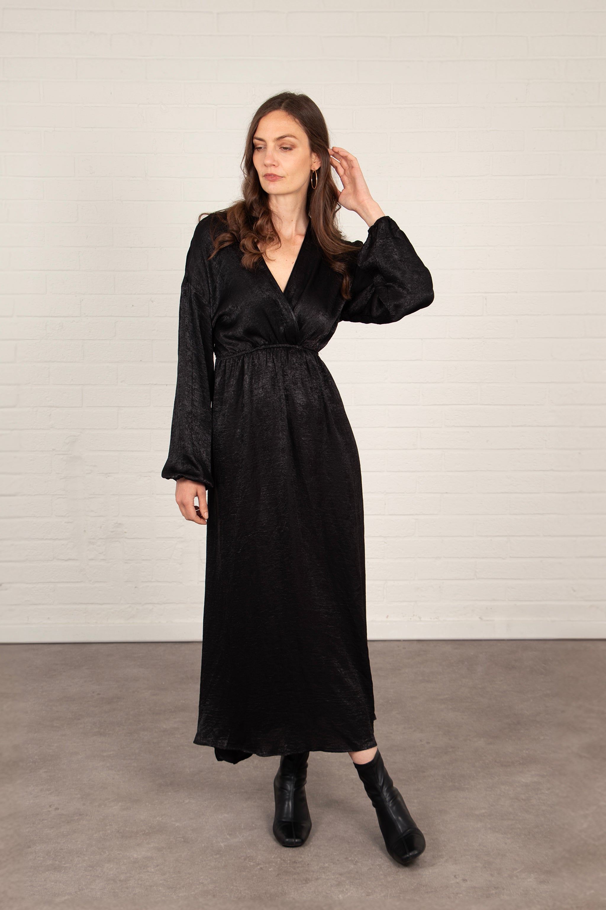 model wearing a long sleeve black maxi dress with a v-neck and faux wrap top