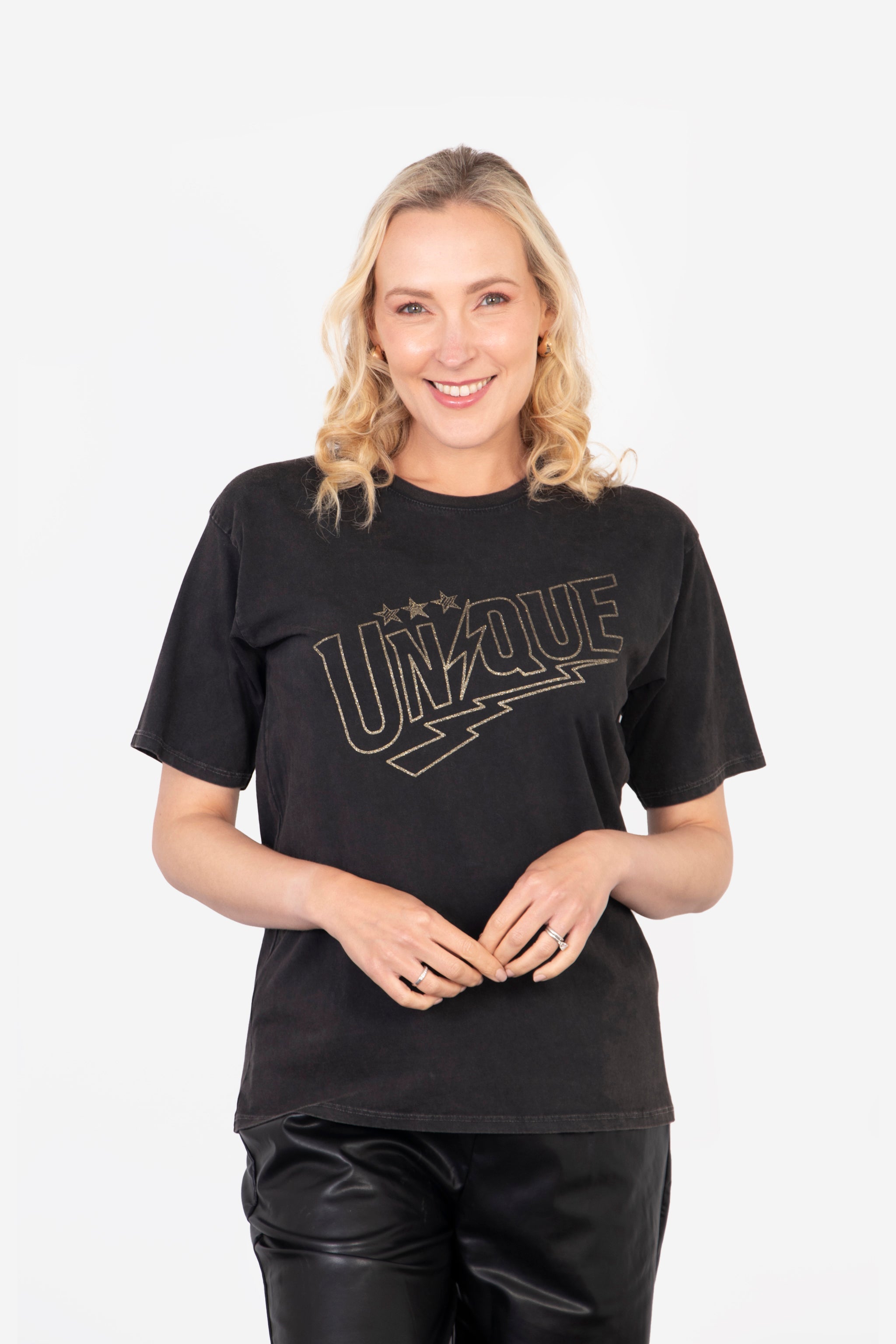 model wearing a black t-shirt with a gold embellished glitter slogan "unique" on the front