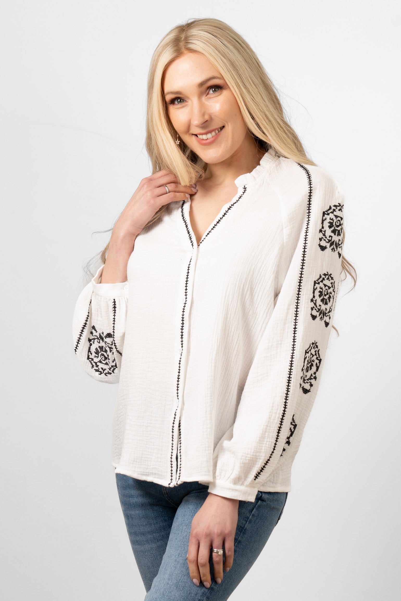 edie-v-neck-button-down-cotton-shirt-white-floral-embroidery-front-view-black-stitching-sleeves-front-closure
