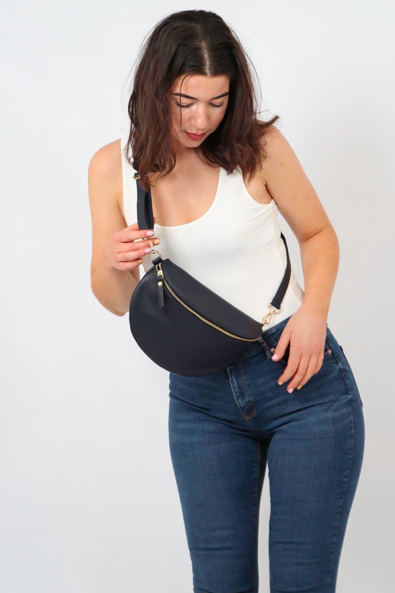 model wearing a large navy blue pebbled leather crossbody bag 